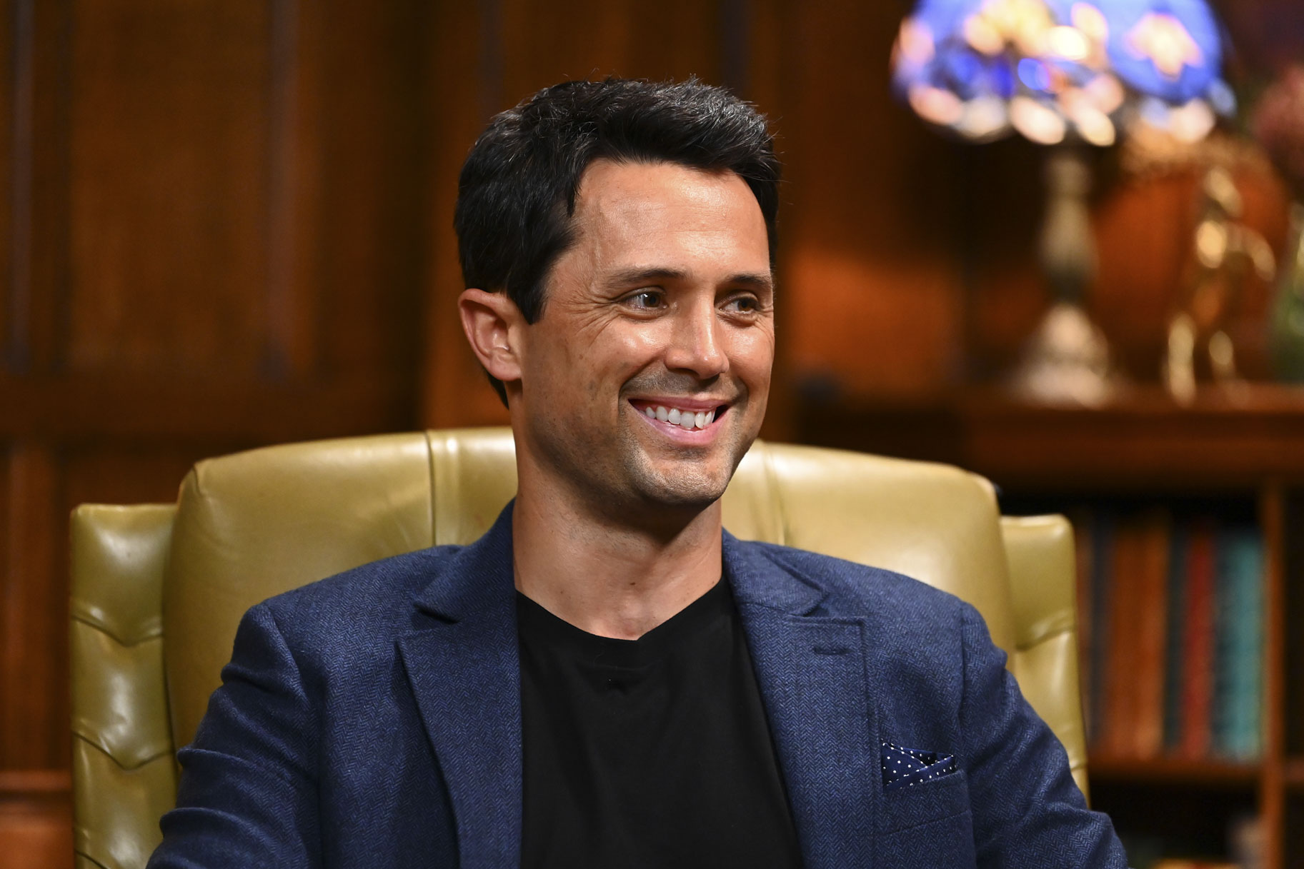 Stephen Colletti smiling while sitting in The Traitors Season 4 Episode 1.