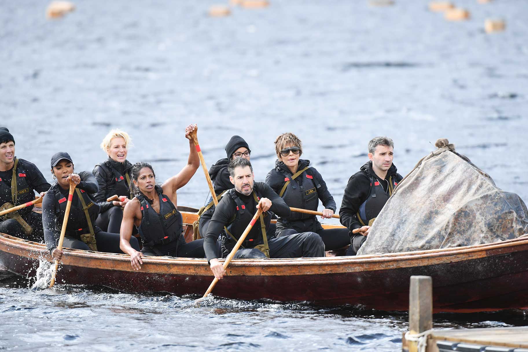 Rob Rausch, Porsha Williams, Dorinda Medley, Natalie Anderson, Tiffany Mitchell, Rob Cesternino, Lisa Rinna, and Ian Terry rowing a boat on The Traitors Season 4 Episode 1.