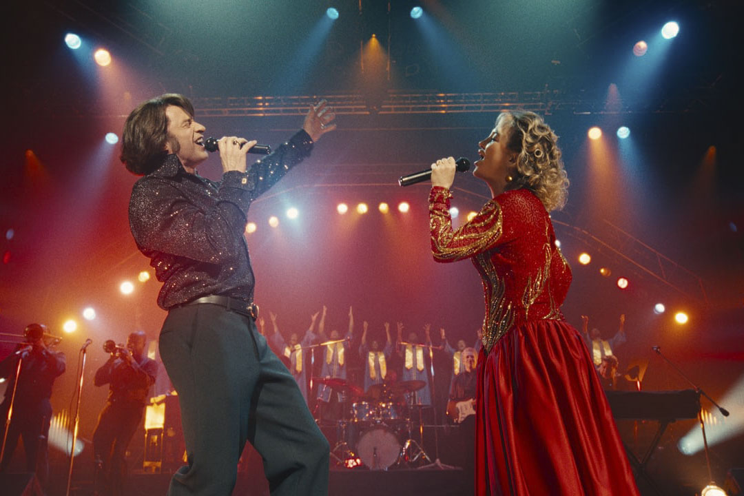 Mike (Hugh Jackman) and Claire (Kate Hudson) sing onstage together in Song Sung Blue (2025).