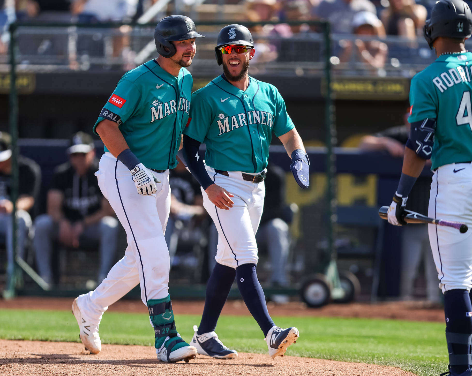 Cal Raleigh and Miles Mastrobuoni of the Seattle Mariners on a baseball feild.