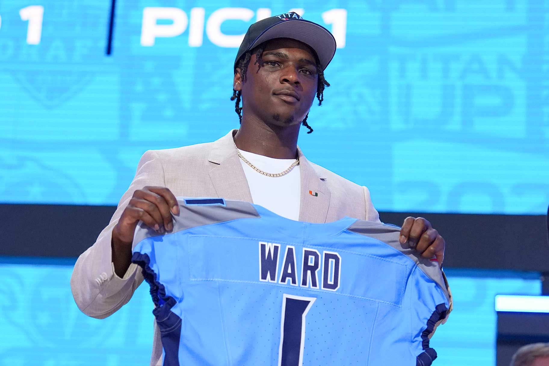 Cam Ward holding up a Tennessee Titans jersey at the 2025 NFL Draft.