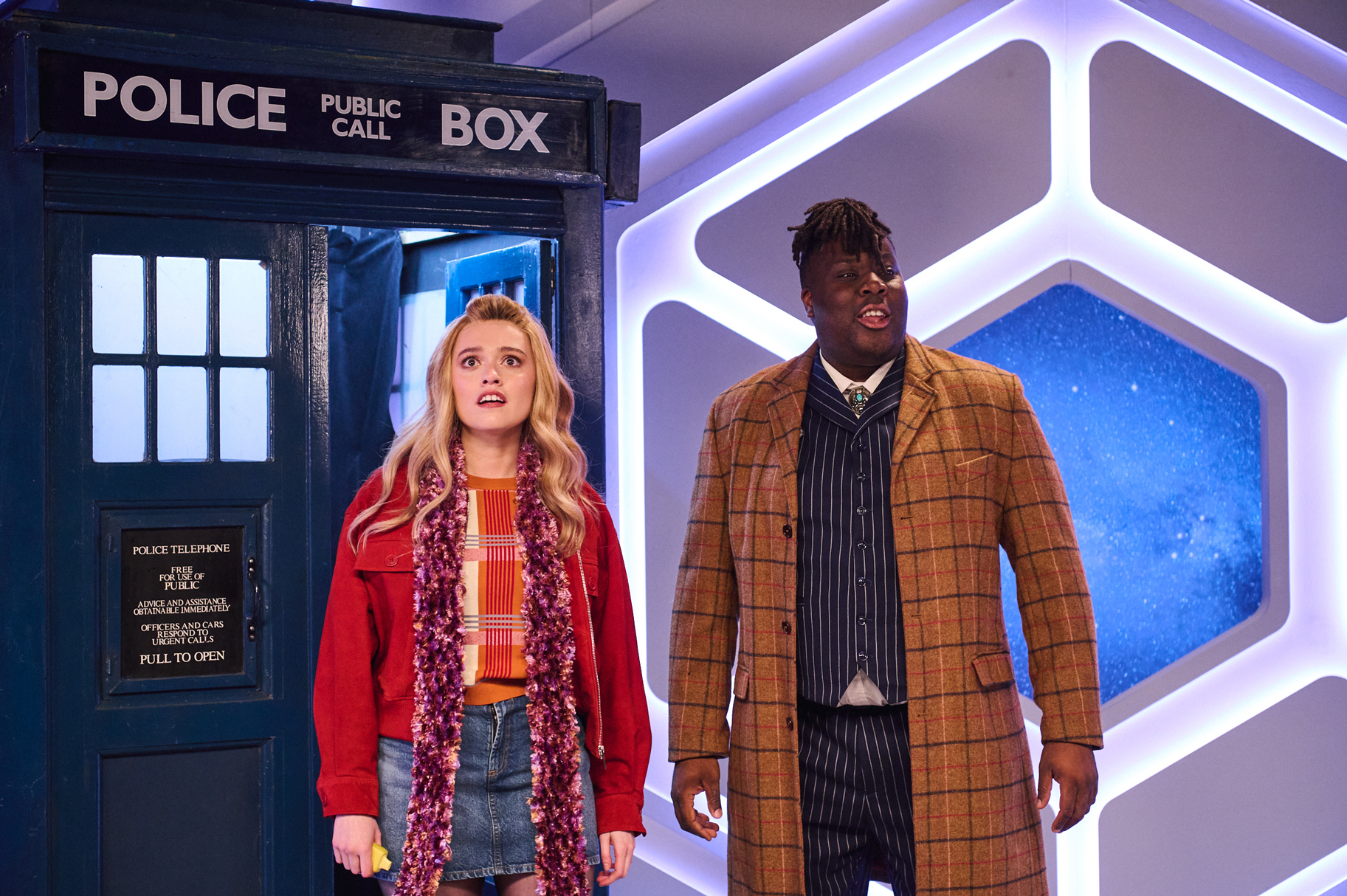 Aimee Lou Wood and Hammed Animashaun in front of a police station set.