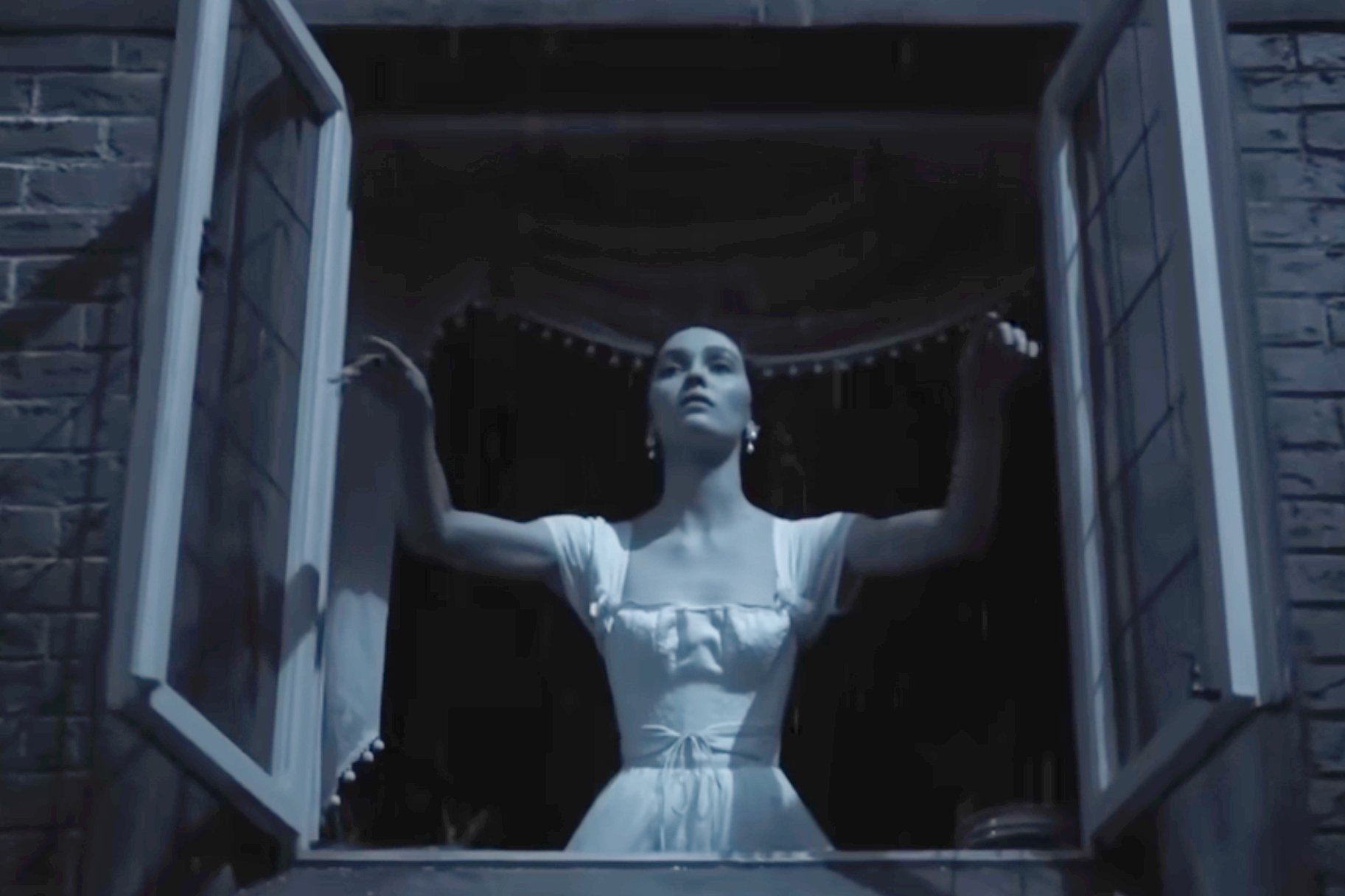Lily Rose Depp as Ellen Hutler standing at an open window.