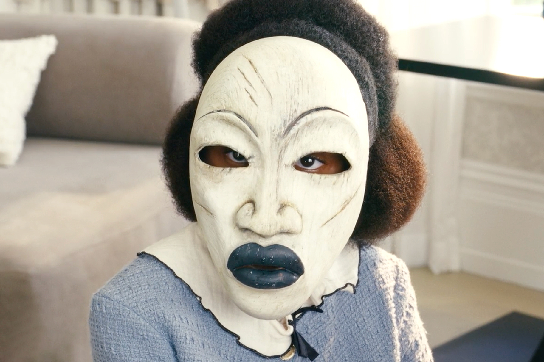 Romy Woods wearing a white mask during the film Strung (2026).