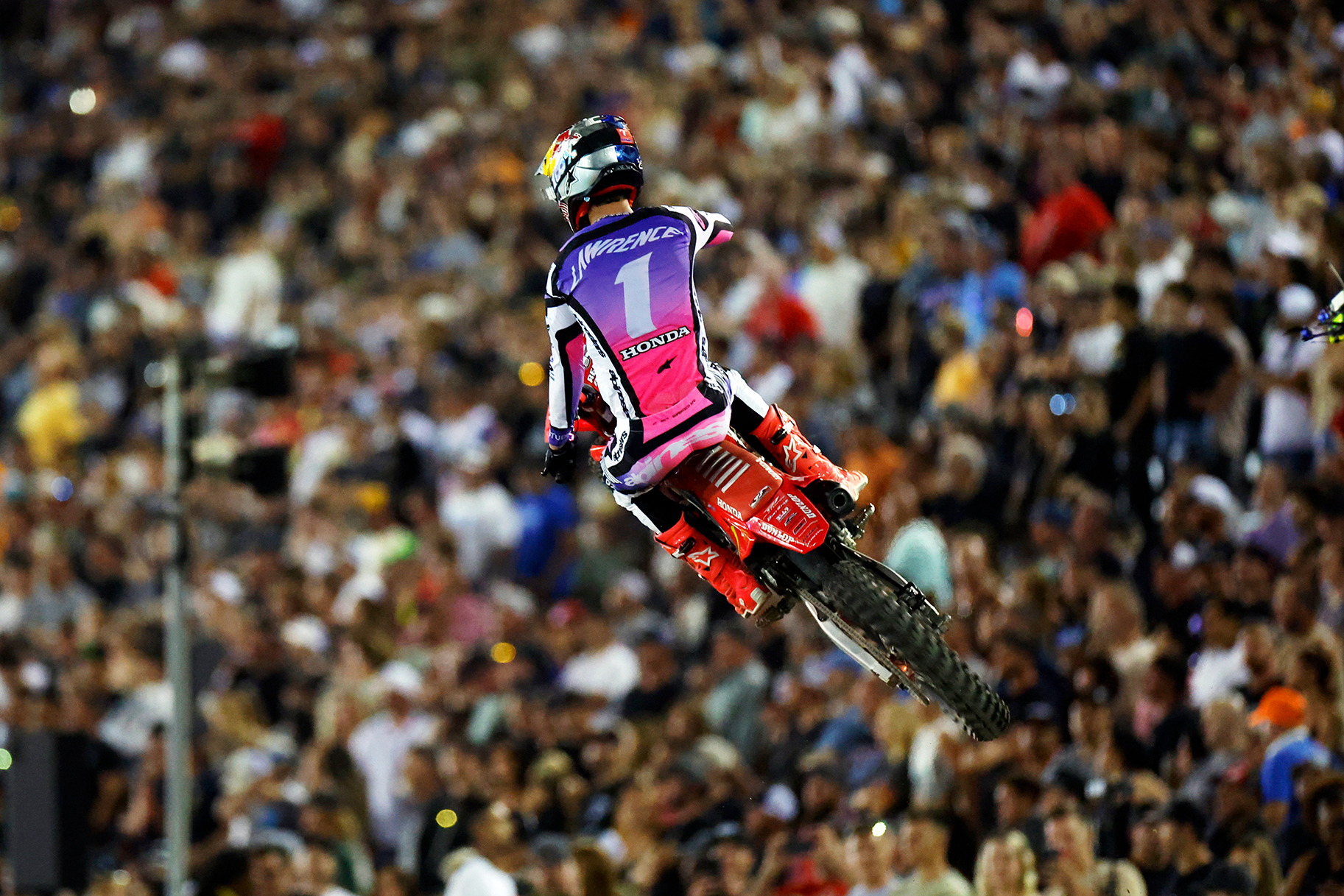 Jett Lawrence jumps in front of fans in the grandstands during the 450 Moto 1 race during the SuperMotocross World Championship Final.