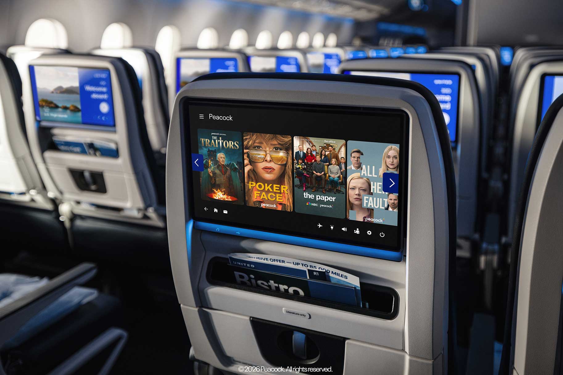 Rows of the back of seats on a United Airlines flight with screens displaying Peacock movies and tv series