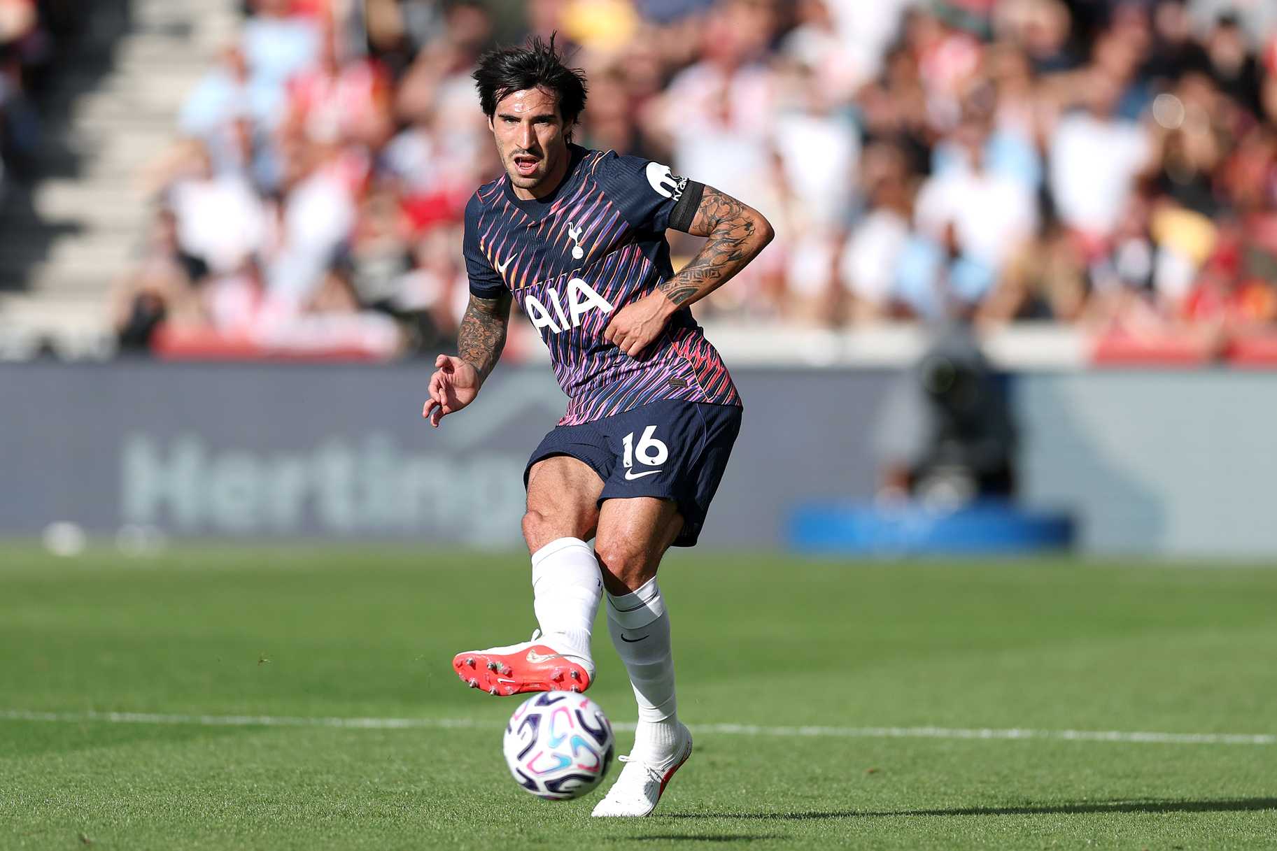 Sandro Tonali kicking a ball on a soccer field.