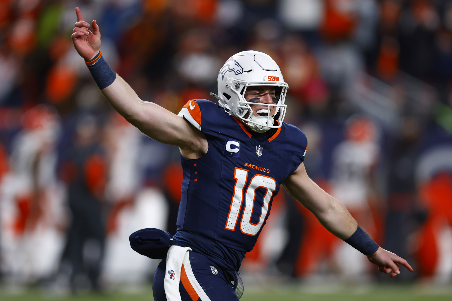 Bo Nix, #10 of the Denver Broncos, celebrating during a game wearing a midnight blue jersey.