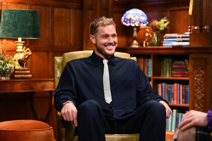 Colton Underwood smiles in a black outfit on The Traitors Episode 401.