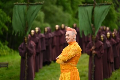 Alan Cumming stands in front of masked and cloaked strangers on The Traitors Episode 403.