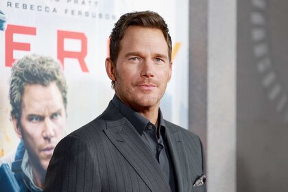 Chris Pratt smiling in a gray suit at the New York Premiere of Mercy.