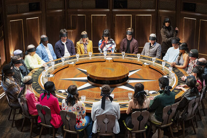 The blindfolded cast of The Traitors UK Season 3 Epsiode 1 sitting at the roundtable.