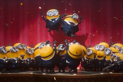 Minions performing on stage and climbing on each other in Minions & Monsters (2026).