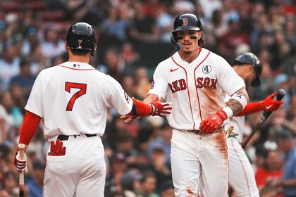Boston Red Sox left fielder Jarren Duran high fives teammate Masataka Yoshida after scoring in the first inning during a game against the Baltimore Orioles.