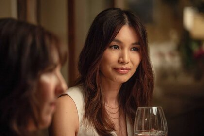 Gigi sitting at a table with wine in The Five Star Weekend Season 1.