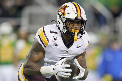 Darius Taylor, #1 of the Minnesota Golden Gophers, holding a football during a game.