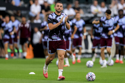 John McGinn of Aston Villa clapping while running on the pitch.