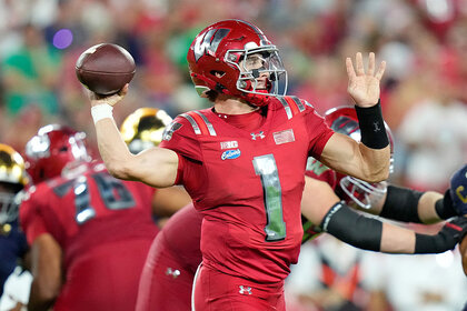 Colton Joseph #1 of the Wisconsin Badgers looks to pass against the Notre Dame Fighting Irish at Lambeau Field.