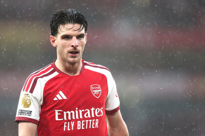 Declan Rice in an Arsenal jersey during a rainy Premier League match against Everton at Emirates Stadium.