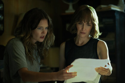 Meghann Fahy as Charlie and Rose Byrne as Sam looking at a document together on The Good Daughter Season 1.