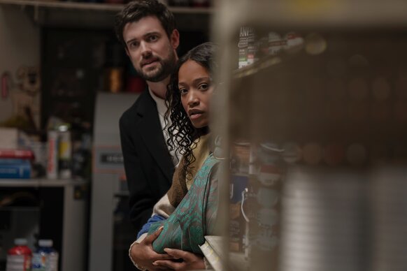 Rob (Jack Whitehall) and Samira (Keke Palmer) peer past a pantry shelf on The Burbs Episode 102.