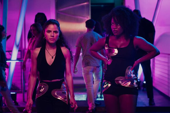 Etta and Lovely standing in a pink lit room in M.I.A. Season 1 Episode 4.