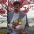Felipe Cruz holding a bouquet of flowers at a park.