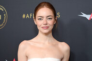 Emma Stone smiling in a white dress at the AFI Awards.