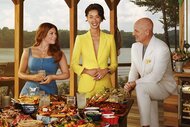 Gail Simmons, Kristen Kish, and Tom Collicchio standing behind a table full of food