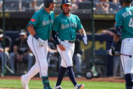 Cal Raleigh and Miles Mastrobuoni of the Seattle Mariners on a baseball feild.