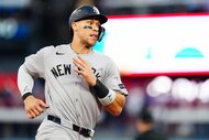 Aaron Judge of the New York Yankees runs to first after hitting a one-run single in the seventh inning during Game Two of the American League Division Series between the New York Yankees and the Toronto Blue Jays.