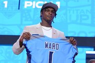 Cam Ward holding up a Tennessee Titans jersey at the 2025 NFL Draft.