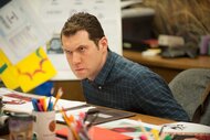 Craig leaning over his desk in Parks and Recreation Season 6 Episode 15.