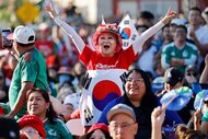 A South Korea fan cheering amongst other fans during the World Cup match between the two countries South Korea and Mexico.