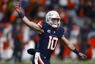 Bo Nix, #10 of the Denver Broncos, celebrating during a game wearing a midnight blue jersey.