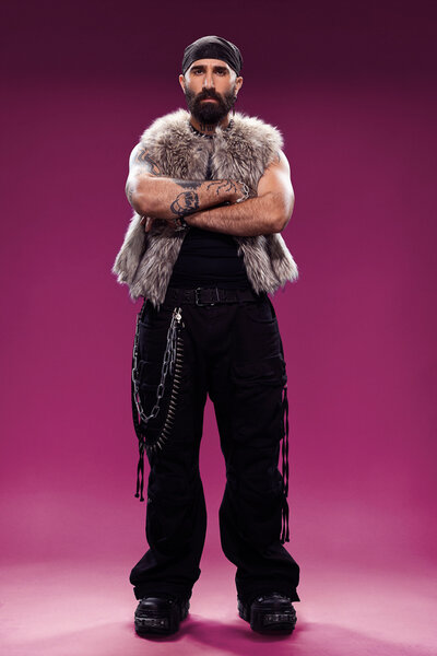 Paul Abrahamian standing in front of a purple backdrop in House of Villains Season 3.