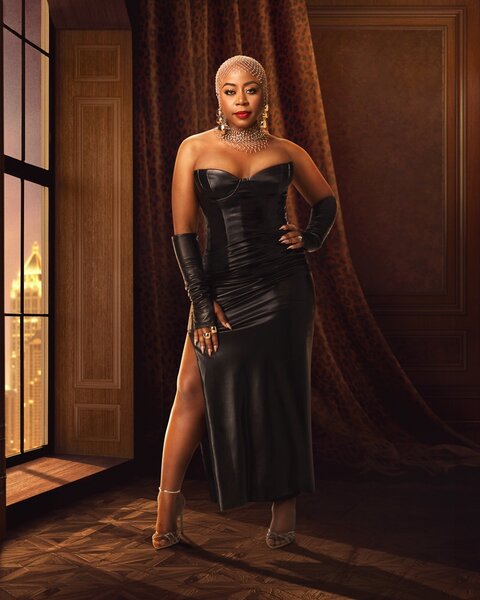 Pinky Cole standing in an ornate room with brown decor.