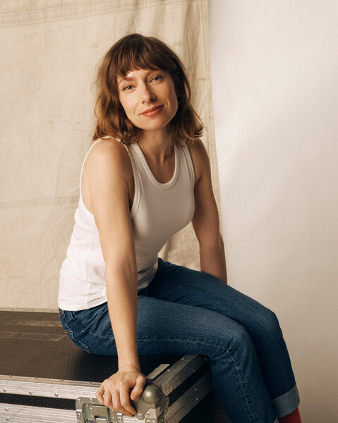 Celeste Dring posing in front of a cream backdrop.
