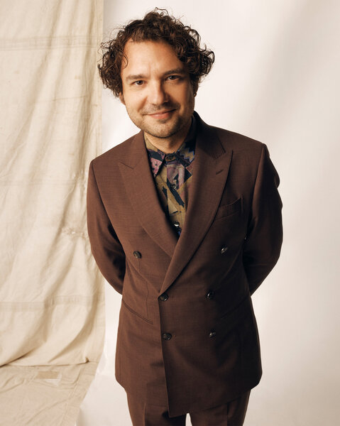 George Fouracres posing in front of a cream backdrop.