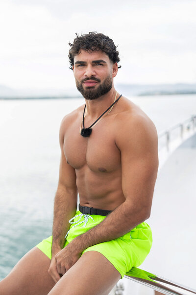 Chaten "Chay" Nehra wearing neon green swim trunks on a boat in Love Island USA Season 8.