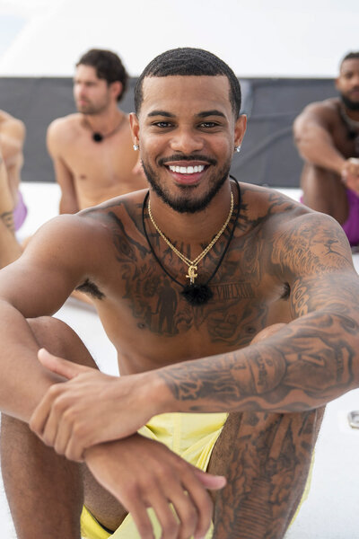Corey Sawyer Jr. sitting and smiling in Love Island USA Season 8.
