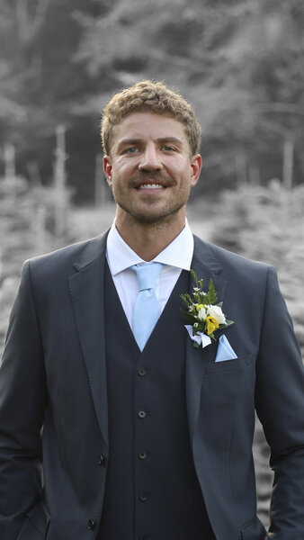 Adam smiles in a suit in Married at First Sight Season 20.