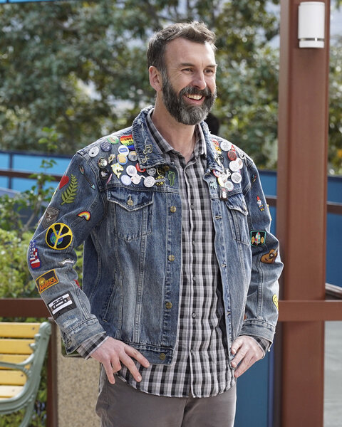 Matt Braunger's character smiling and standing with hands on his hips.
