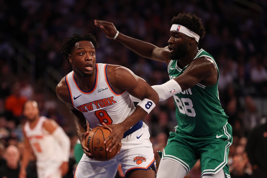 OG Anunoby #8 of the New York Knicks is defended by Neemias Queta #88 of the Boston Celtics.
