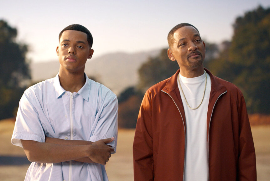 Will (Jabari Banks) and Will Smith standing outside in front of trees together
