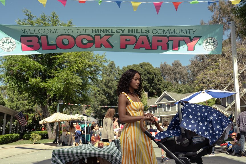 Samira (Keke Palmer) walks past a block party with a stroll on The Burbs Season 1 Episode 4.