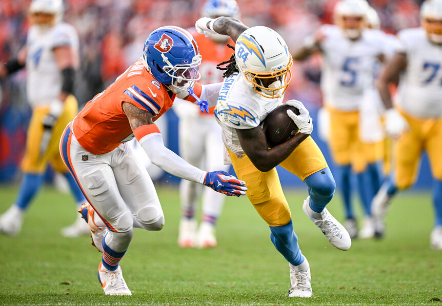 Pat Surtain II of the Denver Broncos tackles Keandre Lambert-Smith of the Los Angeles Chargers