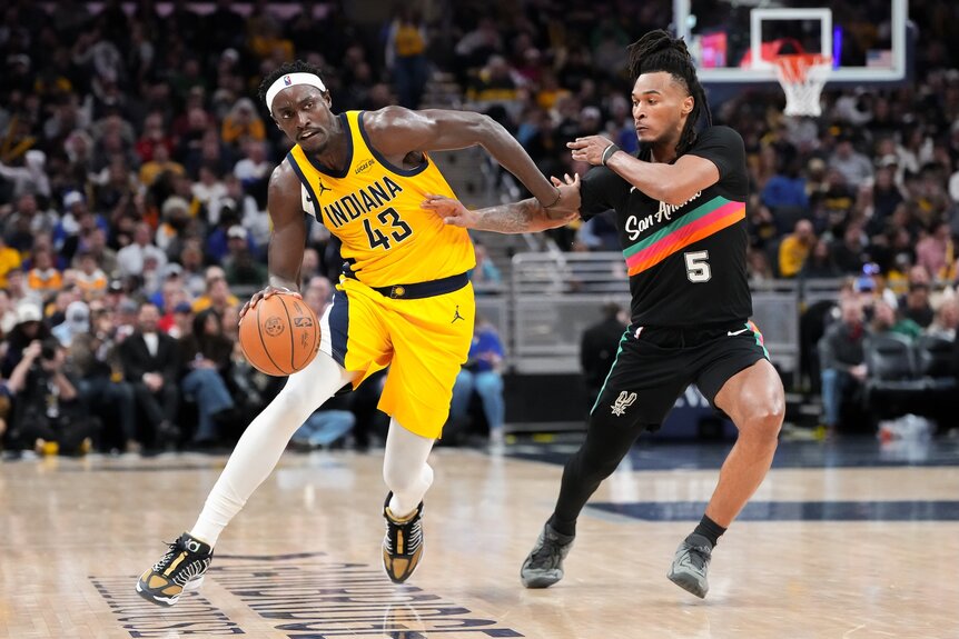 Pascal Siakam #43 of the Indiana Pacers dribbles the ball while being guarded by Stephon Castle #5 of the San Antonio Spurs.
