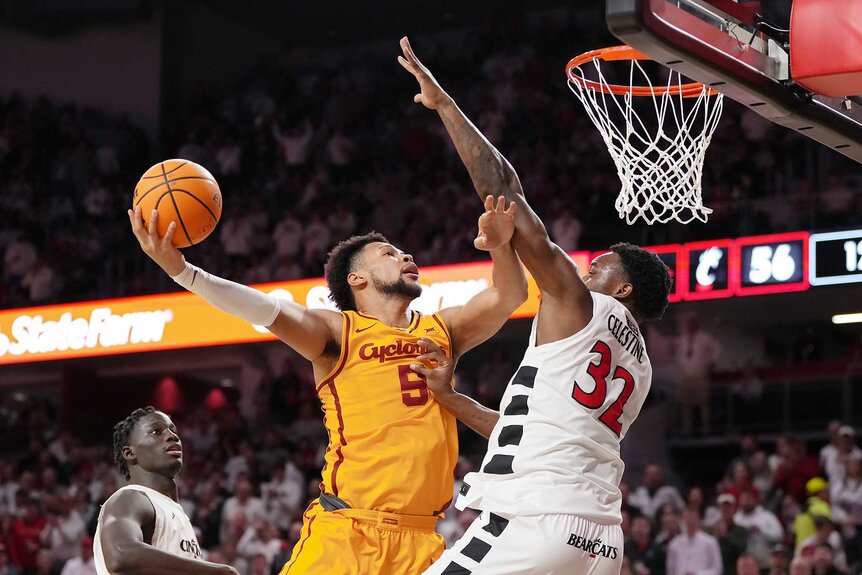 Joshua Jefferson of the Iowa State Cyclones attempts a shot as he is guarded by Jalen Celestine of the Cincinnati Bearcats.