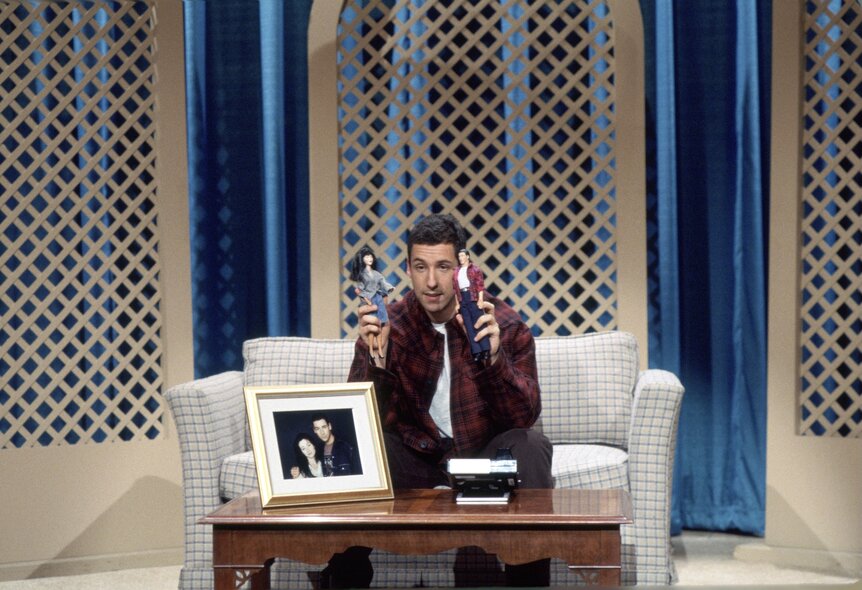 Brian (Adam Sandler) plays with dolls on SNL Episode 1915.